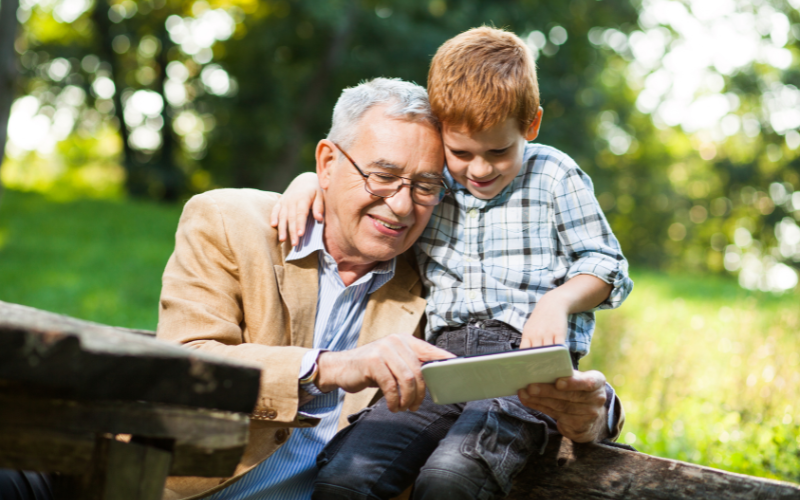 Grandparent with grandchild using a tablet